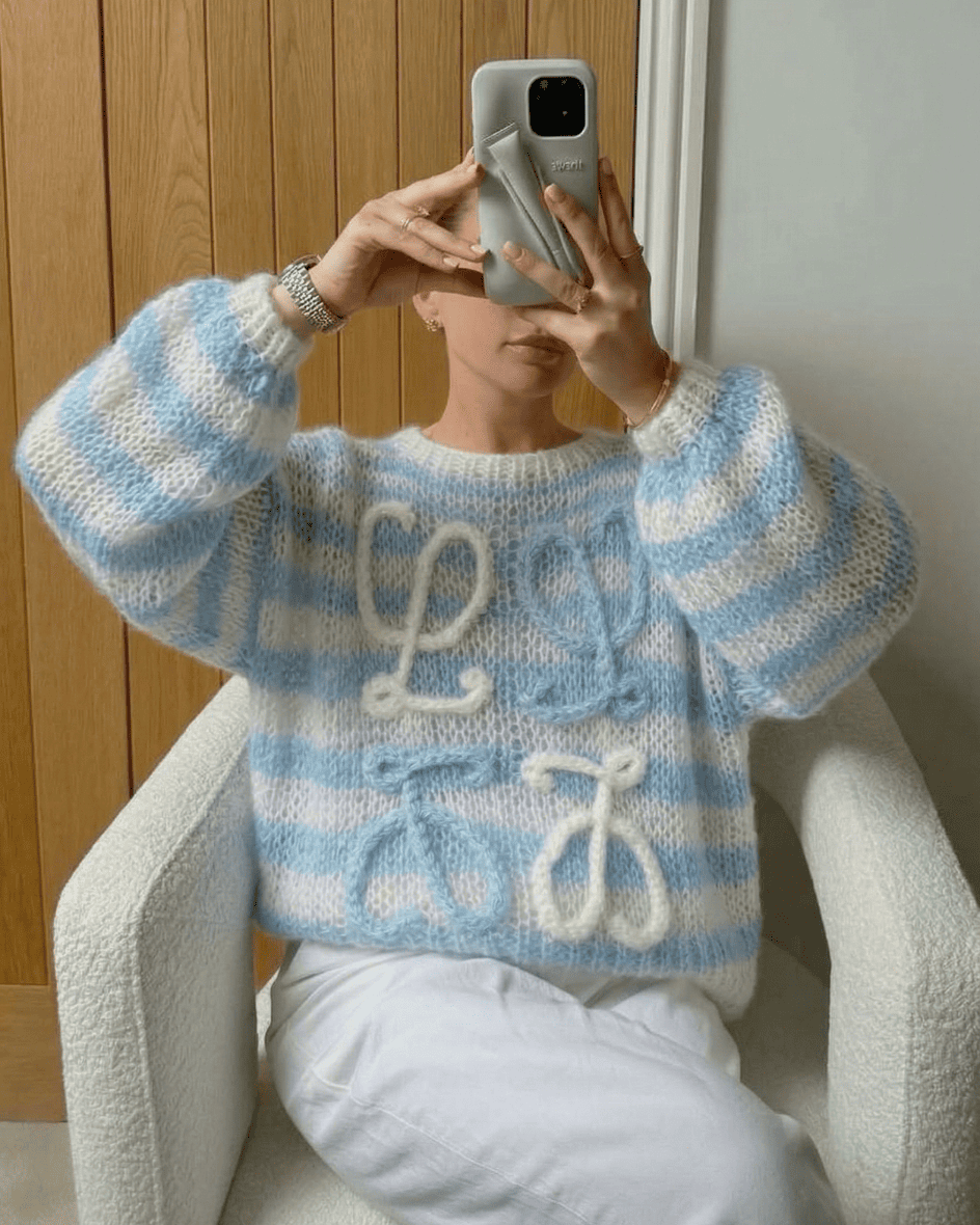 Ciel blue and white striped Loewe sweater styled with white trousers for a clean girl aesthetic.