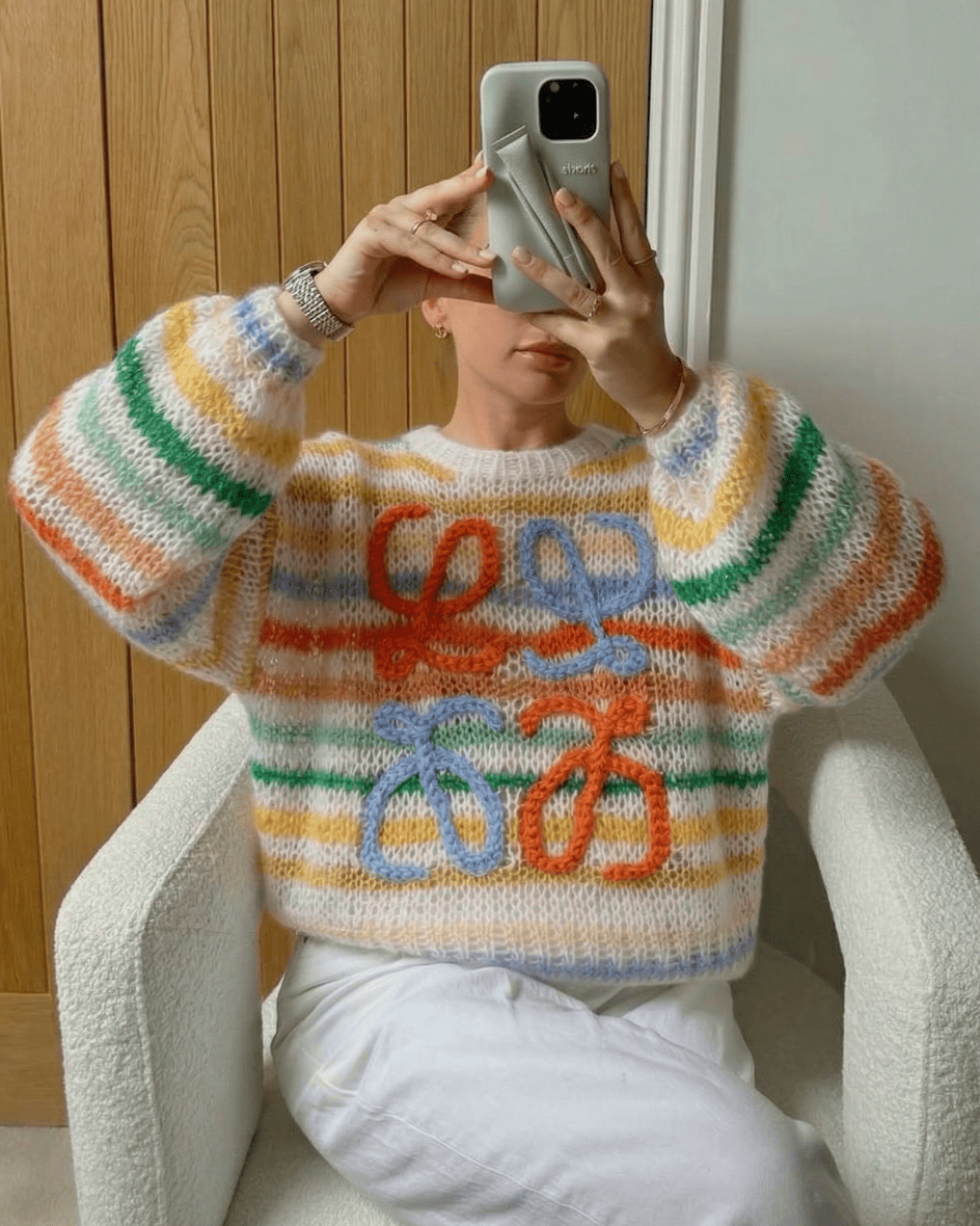 Colorful rainbow striped knitwear styled with white pants, mirror selfie for
main character energy.