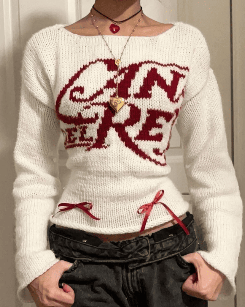  Model wearing the Lana del Rey Ribbon Knit in off-white with red satin bows and vintage Lana Del Rey graphic.