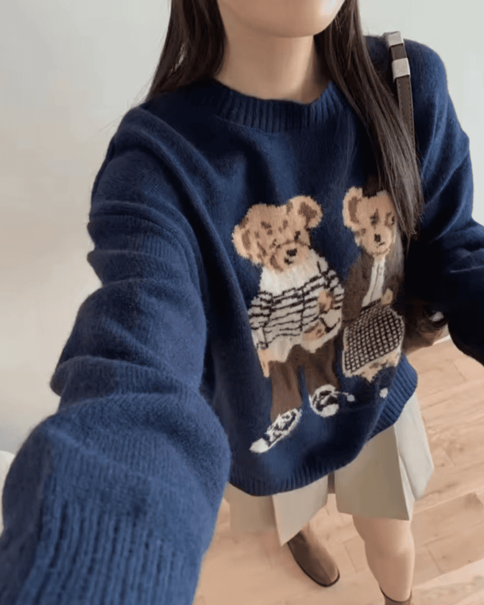 Detail of the oversized silhouette and bear duo embroidery on the navy knit